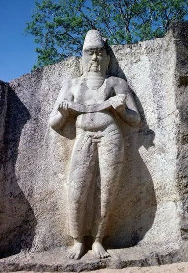 Statue of King Parakramabahu the Great surrounded by historic ruins